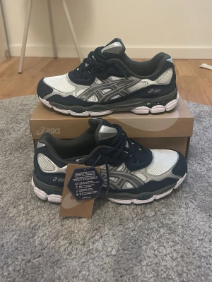 Asics Gel Nyc - blå/vit - Snygga ASICS sneakers i marinblått och vitt med silverdetaljer. De kommer helt nya med box och original tags. Fraktar alltid samma dag! Pris kan diskuteras vid snabb affär!