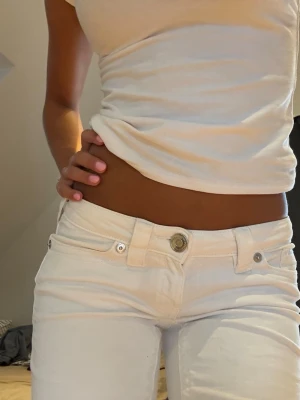 Vita lågmidjade jeans - Intressekoll på dessa super lågmidjade vita jeans. Använda en gång. Väldigt bra skick och inga synliga defekter eller fläckar. Jag är 166cm lång, och jeansen är ner till över hälarna. 