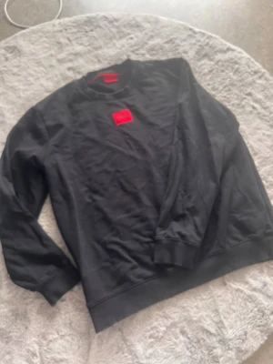 Svart Philipp Plein t-shirt med dödskalle - Säljer en svart t-shirt från Philipp Plein med ett stort grönt dödskalletryck framtill och logga vid halsen. T-shirten har korta ärmar och är gjord i mjuk bomull. Perfekt för dig som gillar edgy och unik stil.