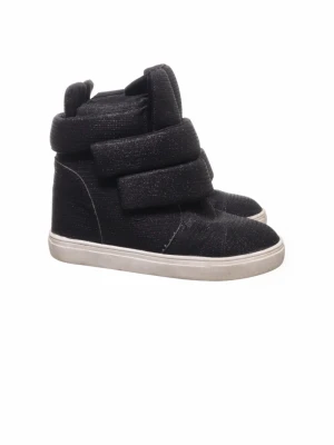 Svarta höga sneakers/kilklackar - Säljer ett par svarta sneakers/kilklackar med högt skaft och tre breda kardborreband. Skorna har en vit sula och är tillverkade i ett tygmaterial med diskret glans. Perfekta för dig som gillar en sportig och trendig look. Aldrig använda endast testade dock köpta på Sellpy så anvönda av tidigare ägaren. Skulle säga storlek 38/39