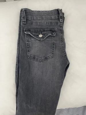 Utåtsvängda jeans från Gina tricot  - Snygga gråa skinny jeans med klassiska fem fickor och en extra ficka med lock bak. Jeansen har dragkedjegylf och silverfärgade knappar. Materialet är mjukt denim med lätt tvättad look som ger en avslappnad vibe.