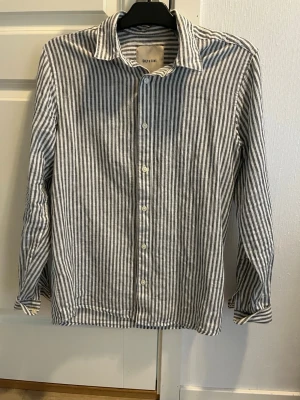 Randig skjorta i linne från Only & Sons - Snygg långärmad skjorta från Only & Sons i vitt och grått med vertikala ränder. Tillverkad i linne för en luftig känsla. Klassisk krage och knäppning framtill. Perfekt för en avslappnad men stilren look Storlek . Tror det är storlek S men stor i storleken 