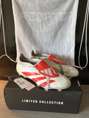 Adidas Predator Limited Edition - Trent Alexander Arnold - Säljer ett par Trent Alexander Arnold Adidas Predator fotbollsskor i Limited Collection-upplaga. Skorna är vita med röda detaljer och har klassisk Predator-design med täckt snörning och gummidetaljer för extra grepp. Tillverkade i syntetmaterial och levereras med tillhörande dustbag. Sälj med ett otroligt bra pris för att jag inte behöver dem och vill få dem sålt😊