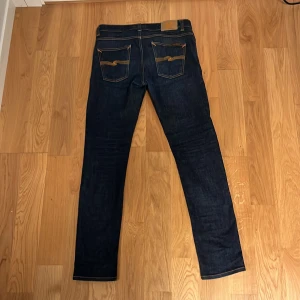 Nudie jeans (Lean dean) - Säljer dessa feta jeansen i mycket bra skick. Jeansen är i storlek W32/L34 men är lite mindre i storleken. Hör av dig vid fler frågor eller bilder🤙🤙. Pris inte hugget i sten🪨