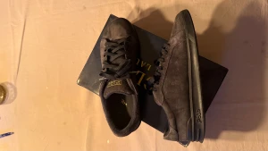 Svarta sneakers från Polo Ralph Lauren - Snygga svarta sneakers från Polo Ralph Lauren i mocka med diskret logga på sidan och Polo-detalj på hälen. Skorna har svart snörning, platt sula och en stilren, låg profil som passar till det mesta. Perfekta för dig som gillar klassisk och clean streetstil.