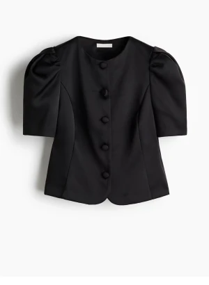 Svart blus med puffärm och knappar - Snygg svart blus med puffiga korta ärmar och stora klädda knappar framtill.Det är bara att skriva om ni är intresserade lappen är kvar och den är aldrig andvänd