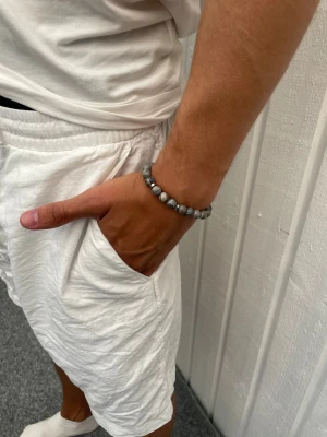 STENARMBAND - 8mm Ljusgrå - Snyggt STENARMBAND från Montore. 8mm pärlor med metalldetaljer. Vid fler frågor eller funderingar, hör av dig!