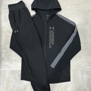 UNDER ARMOUR - Storm Tracksuit - Under Armour – Storm Tracksuit • Jacka och byxa i matchande färg • Storlekar från XS till 2XL • Går också att få den på sneaks,se
