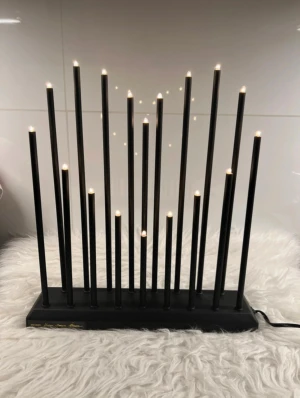 Designad elektrisk ljusstake - Modern elektrisk ljusstake i svart design av Ylva Skarp. Stilren och unik med 16 LED-ljus i olika höjder, perfekt för fönster eller som dekor. Levereras med originalkartong, i mycket fint skick utan synligt slitage. Strömkabel medföljer.
