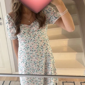 Blommig kortklänning💕 - Supersöt kortklänning med blommigt mönster i pastellfärger. Klänningen har puffärmar, söt rynkning vid bysten och smock i ryggen för extra komfort. Perfekt för varma dagar och har en ljus, fräsch känsla. Materialet känns lätt och luftigt. Bara använd en gång från bubbelroom💕🌸