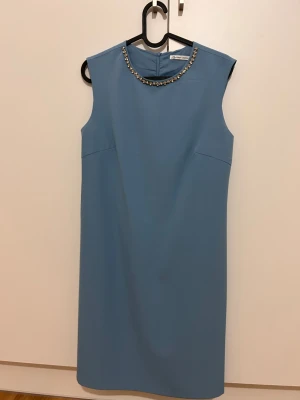 Blå ärmlös klänning  - Snygg blå klänning från Zarina Collection med ärmlös design och rund halsringning dekorerad med pärlor. Klänningen har en rak, enkel siluett och dragkedja i ryggen. Perfekt för dig som gillar stilrena detaljer och vill ha något som sticker ut. EU-storlek 38 (på klänningen står det 44)