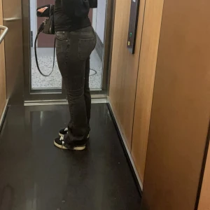 Svarta bootcut jeans med hål - Säljer ett par svarta jeans med bootcut passform, fransiga kanter vid bensluten. Jeansen har klassisk femficksdesign och är tillverkade i jeansmaterial. Snyggt slitna detaljer vid knäna. Pris kan diskuteras.