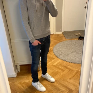 Replay Anbass mörkblå jeans slim fit - Säljer ett par Replay Anbass jeans i mörkblå tvätt med snygga slitningar och kontrastsömmar. Modellen är slim fit med klassisk femficksdesign. Jeansen har Replay-logga på fickan och är tillverkade i stretchigt jeanstyg för skön passform.
