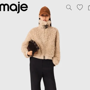 Beige teddyjacka från Maje - Supermjuk och fluffig teddyjacka i beige från Maje. Jackan har hög krage med snygga spänndetaljer i mörkbrunt läder. Perfekt för dig som vill ha en cozy och trendig look. Helt ny med prislapp och kvitto. Inte använd då jag har en liknande. I storlek 40 men passar snyggt oversized på mig som är S. Pris i butik är 5099kr. Kan gå ned i pris vid snabb affär🩷