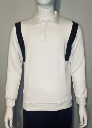 Tjock tröja  - En bekvämt tjock tröja som är gjort av 100% bomull och stilren långärmad tröja i vitt med svarta detaljer över axlarna. Den klassiska kragen och den diskreta knäppningen framtill ger en modern och sportig look – perfekt både till vardags och till en mer uppklädd stil.