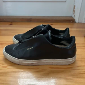 Svarta sneakers från Axel Arigato - Snygga svarta sneakers från Axel Arigato. Välanvända men fortfarande i bra skick. Orginal lådan följer med
