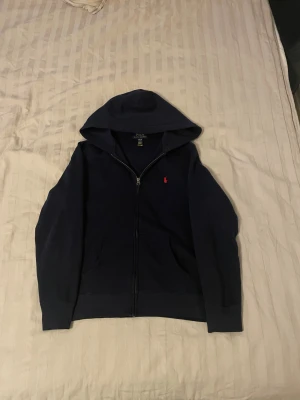 Ralph lauren hoodie 14-16 - Säljer nu min ralph lauren hoodie i storlek 14-16. Då den har blivit för liten. Knappt använd. Köpt april 2024 (inget kvitto finns kvar). Köpt från Ralph laurens hemsida. Inga tecken på användning.