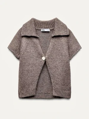 Beige stickad kofta från Zara - Säljer en brun stickad kofta från Zara med korta ärmar och bred krage. Koftan har en knapp framtill och ribbade detaljer vid krage, ärmslut och nederkant. Inte mycket använd.