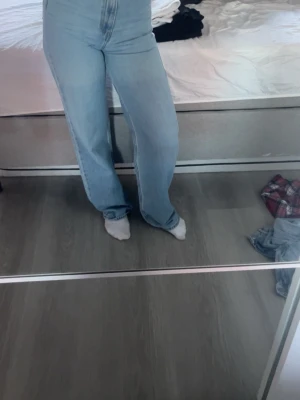 Ljusblå Levi's jeans med wide fit - Säljer ett par ljusblå Levi's jeans med klassisk femficksdesign och hög midja. Jeansen har en wide fit och raka ben, vilket ger en chill och trendig look. Materialet är slitstarkt denim och bakfickorna har den ikoniska Levi's-sömmen.