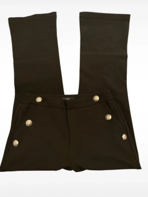 Svarta bootcut byxor med silverknappar - Svarta bootcut byxor från Zara med sex dekorativa silverknappar framtill. Byxorna har hög midja och är tillverkade i ett mjukt material som ger en snygg passform. 