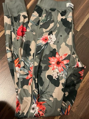 Blommiga camouflage underställsbyxor  - Stretchigt material som sitter skönt och följer kroppens rörelser. Från sportshoppen! Underställsbyxor