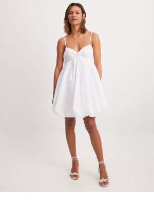 Vit kort klänning  - Söt vit kort klänning med tunna axelband som man kan knyta både. Klänningen har en ballongformad kjol och smock i ryggen. Använd två gånger💞