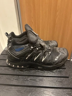 Salomon X Ultra 3D Gore-Tex sneakers - Svarta Salomon X Ultra 3D sneakers med Gore-Tex membran och snabbsnörning. Skorna har robust design, platt sula och detaljer i grått och vitt. Perfekta för äventyr och outdoor med slitstark syntet och mesh. Sulan har Energy Cell 2 för extra komfort.