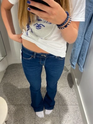 Blå bootcut jeans låg midja - Snygga blå jeans med bootcut-snitt och låg midja från HM. Midja rak över 35cm, innebenslängden 78cm