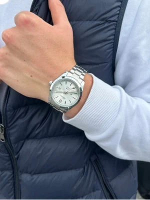 Vit klockan från Doventi  - Stilren herrklocka från Doventi med blå urtavla och silverfärgat armband i metall. Klockan har datumvisning och klassisk rund form med tydliga indexmarkeringar. Perfekt accessoar för dig som gillar en clean och modern look.