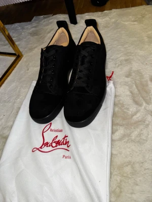 Svarta sneakers från Christian Louboutin - Säljer ett par helt nya svarta skor från Christian Louboutin, Dammpåse tillkommer. Skorna passar t.om storlek 44-45, Skön, ete kvalite