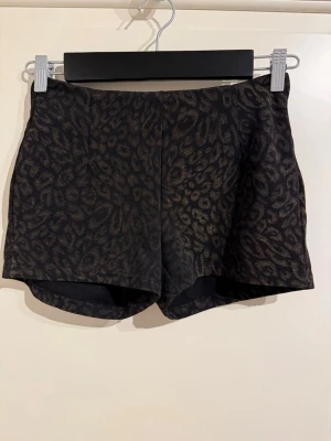 Leopard shorts - Shorts med leopardmönster i guld. Dragkedja baktill och medelhög i midjan. Jättesnygga men kommer inte till användning.