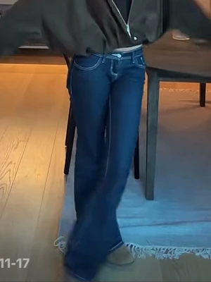 Svarta lågmidjade bootcut jeans med kontrastsömmar - Snygga svarta jeans med bootcut-modell och vita kontrastsömmar. Klassisk femficksdesign och låg midja. Jeansen har en figurnära passform upptill och utsvängda ben, vilket ger en trendig siluett. Tar gärna mått och fler bilder om det behövs! 🩵