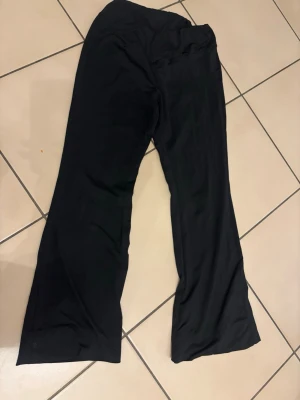 Svarta wide byxor i mjukt tyg - Säljer ett par svarta byxor med wide passform och långa ben. Byxorna är tillverkade i ett mjukt och följsamt material som ger en skön känsla. Perfekta för dig som gillar en avslappnad och trendig stil.