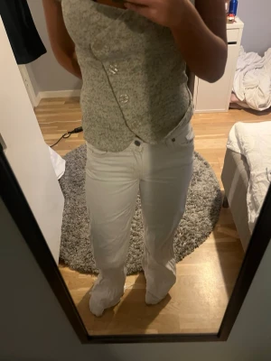 Vita wide jeans med normal passform - Säljer ett par vita jeans med breda ben och klassisk femficksdesign. Byxorna har normal passform och är tillverkade i ett mjukt bomullsmaterial. Jag har sprättat där ner på jeansen så de är längre