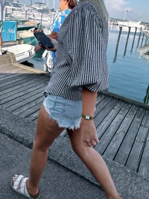 Ljusblå denimshorts med slitningar - Skitsnygga, högmidjade ljusblå jeansshorts från Zara i storlek 32! Använda endast 1-2 gånger och därav väldigt fint skick!! Ser ut som nya. 