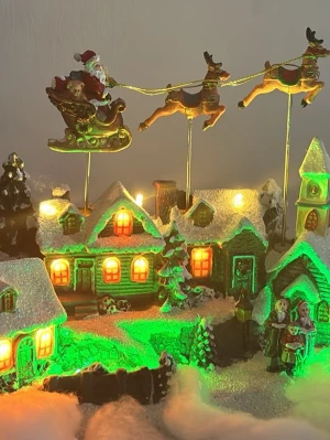 Julby: Jjuldekoration med tomte, renar och hus.  - Funkar som det ska (ljud och belysning) i orginal förpackning   Drivs av batterier eller medföljande nätadapter. Höjd 21 cm. Bredd 30 cm.  Effekt 1,35 W Batterityp AA/LR6  Antal batterier 3 st