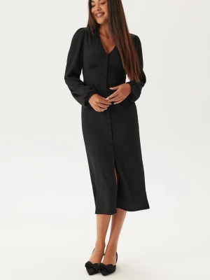 Svart knälång klänning med knappar - Superfin helt ny svart klänning ifrpn bubbleroom. Prislapp finns kvar, säljs då den inte kommer till användning. Mjuk och skön i materialet. Storlek S skulle säkert passa en M. Nypris 599kr