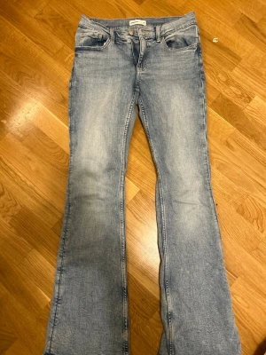 Bootcut ljusblå jeans från Gina tricot - Säljer ett par ljusblå jeans från Levi's med klassisk bootcut-passform. Jeansen har fem fickor, knapp och dragkedja fram samt bälteshällor. Materialet är slitstarkt denim och färgen är snyggt tvättad för en cool look.