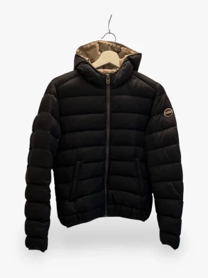 Svart pufferjacka från Colmar - Svart pufferjacka från Colmar med beige foder och huva. Jackan har en rak passform, horisontella quiltade sektioner och dragkedja framtill. Märkeslogga på ärmen och två sidofickor. Perfekt för kalla dagar och snygg till streetwear. Inga defekter, använd max 3 ggr. Vid intresse kom privat!💕