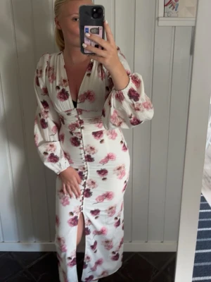Vit blommig långklänning med knappar - Så så fin adoore liknande klänning ifrån Ginatricot som ej kommer till användning, den är använd endast 1 gång!