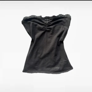 Söt topp med spetsdetaljer - Svart bandeau tubtopp med rynk framtill och liten rosett upptill. Använd några fåtal gånger 