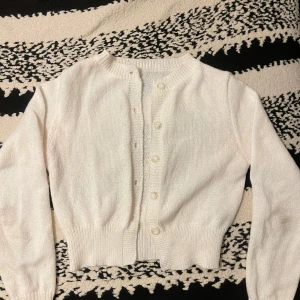 Vit stickad kofta med knappar - Säljer min fina stickad set i beige/cremefärgad. Det är en cardigan/kofta med matchande kjol. Båda är i storlek M