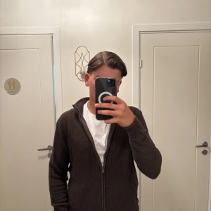 Olivgrön kofta med dragkedja Indicode - Säljer en olivgrön stickad kofta från Indicode i storlek medium. Koftan har hel dragkedja framtill, hög krage och långa ärmar. Perfekt för lager-på-lager och chill stil. Materialet är mjukt och ger en clean look. Den är oanvänd så 10/10 