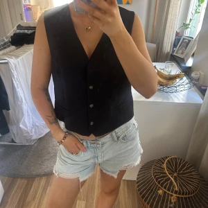 Söt liten svart väst - En söt liten svart väst från H&M som är för stor på mig. Lkte kostymliknande material. Den är i storlek M men vill man ha den lite mera loose så går den ju bra till en typ S också!