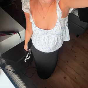 Blommig vit blus med rosett från Nelly - Supersöt blommig blus i vit med ljusblå och gröna detaljer. Blusen har volangärmar, v-ringning och en stor rosett i ryggen som ger extra charm. Materialet känns lätt och luftigt, perfekt för varma dagar. Den är i storlek xs och är i nyskick, använd 1 gång❣️Nypris 350❣️ 