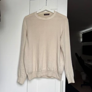 Beige stickad tröja från Oscar Jacobson - Säljer en stilren beige stickad tröja från Oscar Jacobson. Perfekt plagg inför hösten. Storlek S men kan nog passa XS