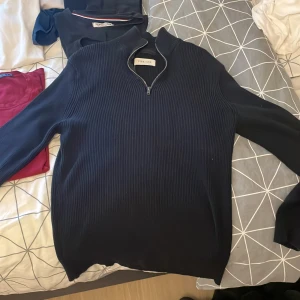 Svart ribbad half zip tröja Pier One - Svart långärmad tröja från Pier One med ribbad struktur och half zip-dragkedja vid halsen. Snygg ståkrage och stilren design som funkar till många olika looks. Materialet känns mjukt och är troligtvis bomull eller polyester. Perfekt för dig som gillar minimalistisk stil.