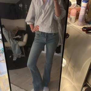 Blå bootcut jeans med klassisk look - Säljer ett par ljusblå jeans med bootcut-modell och klassisk femficksdesign. Jeansen har normal passform och är tillverkade i mjukt denimtyg som ger en avslappnad vibe. Perfekta för dig som gillar en tidlös och enkel stil.