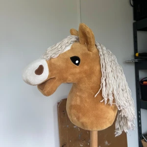 Käpphäst - Det här är ingen bok, utan en käpphäst – perfekt för dig som gillar att leka, tävla eller skapa egna äventyr! Den har en mjuk brun hästhuvud med vit man och sitter på en stadig träpinne. Passar både till hobby och fritid. Fleece skulle jag tro att materialet är🥰