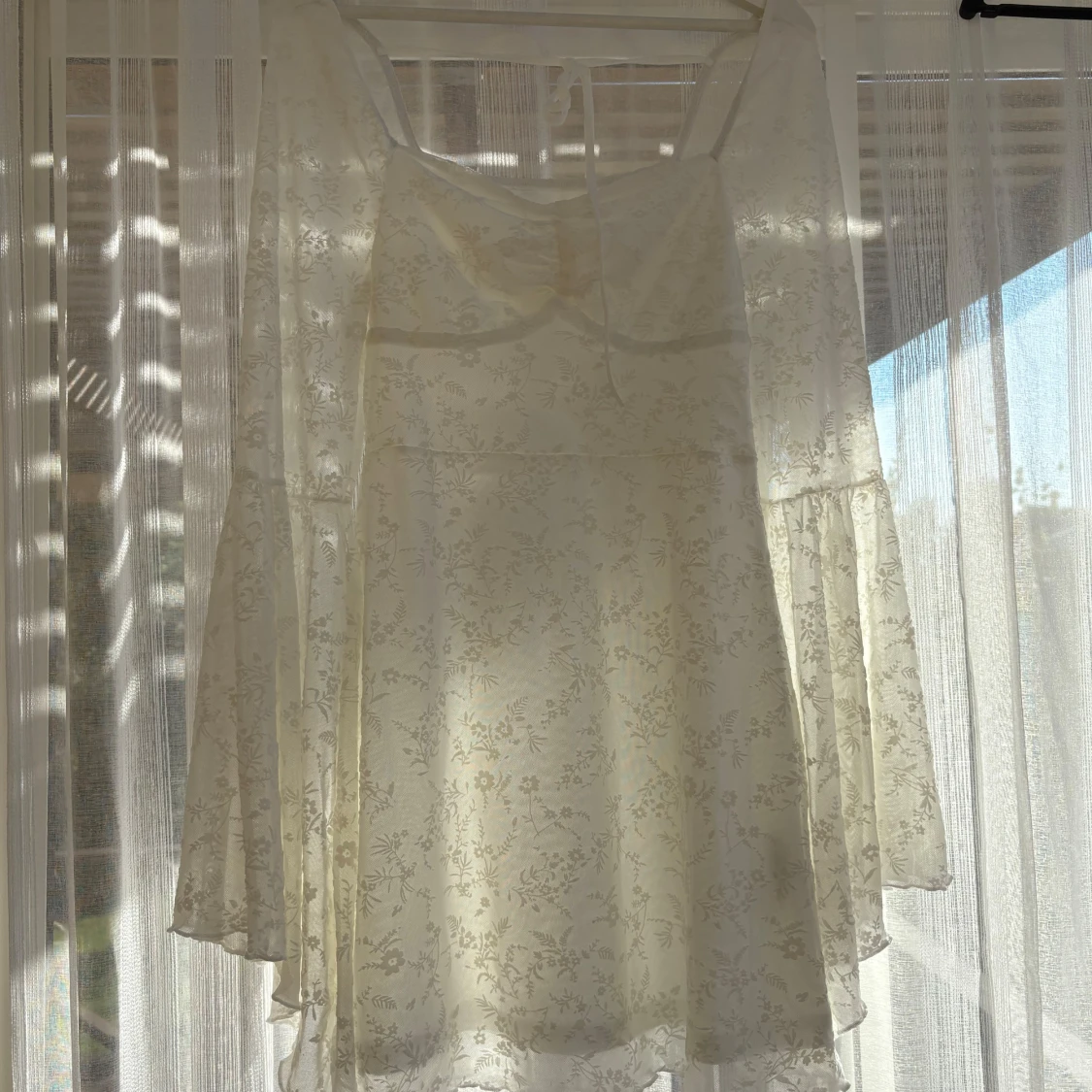 Vit blommig kortklänning med trumpetärm